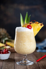 Wall Mural - Pina colada cocktail with cherry, pineapple and leaves