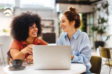 Collaboration over coffee: Two women working together in a cafe