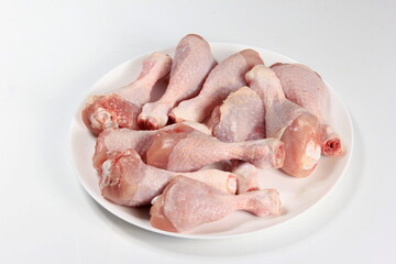 Wall Mural - Raw chicken legs with spices on a white background, close-up. chicken drumsticks raw