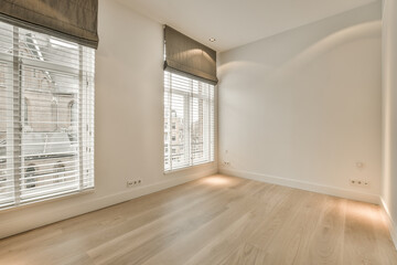 an empty room with wood flooring and white shuttered window coverings on either side of the room, there is a view