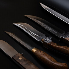Damascus steel knives on a black background. Kitchen knives. background with japanese knife. A set of Japanese Damascus steel knives. Banner