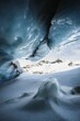 A vertical shot from the interior of an ice cave with shades of blue in Lotschental, Valais(Wallis)