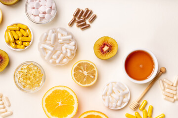 Wall Mural - Food supplements, vitamins and minerals in form of pills, capsules and tablets. Oranges, honey and kiwi from above on bright yellow background. Healthy lifestyle. Natural vitamins from fruits.