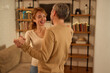 © Stockphotodirectors - Mature couple dancing together in modern living room at home