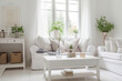 © Trinette Reed - Cozy cottage style living room with white linen sofa and plants
