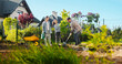 © ihorvsn - Cheerful and happy Caucasian family planting tree together in orchard and watering it with water from pot. Summer work in garden at house. Mother, father and daughter spending time at countryside.