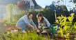 © ihorvsn - Caucasian happy beautiful mother and teen daughter digging in ground and planting flowers in garden on sunny summer day. Pretty girl with mommy in orchard. Outdoors. Helping mom.