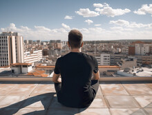 A Man Sitting On A Ledge Looking Out Over A City. AI Generative Image