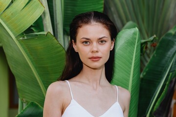 Sticker - Beauty portrait of a young woman brunette with long hair in front of palm trees, face and body skin care concept, the tropics, advertising beauty products