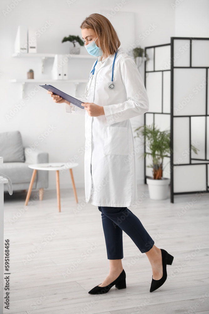 Female doctor with clipboard in modern clinic