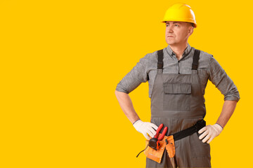 Canvas Print - Mature carpenter in hardhat on yellow background