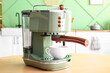© Pixel-Shot - Modern coffee machine with cup on wooden table in kitchen