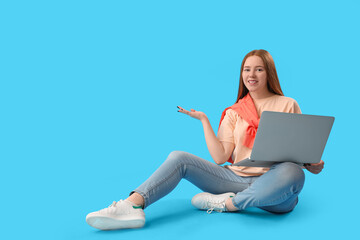 Female programmer with laptop showing something on blue background