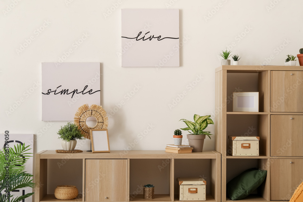 Interior of light bedroom with houseplants and shelving unit