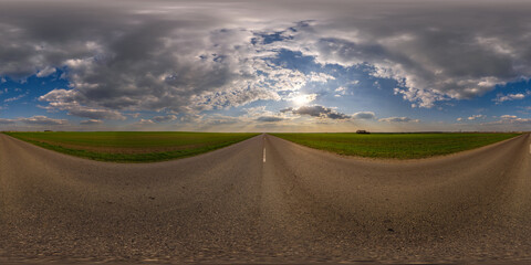 Wall Mural - spherical 360 hdri panorama on old asphalt road with cracks with clouds and sun on evening blue sky in equirectangular seamless projection, as sky replacement in drone panoramas, game development