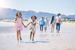 © Azeemud/peopleimages.com - Children running, family bonding and happy at the beach for travel, morning walking and holiday. Smile, summer and girl siblings holding hands on a walk at the ocean with parents and grandparents