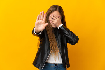 Wall Mural - Child over isolated yellow background making stop gesture and covering face