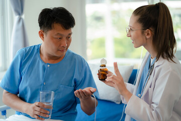 medicine, healthcare and people concept - doctor talking to male patient at bed in hospital.