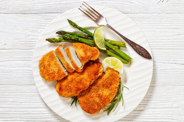 Wall Mural - breaded chicken breasts with asparagus and lime