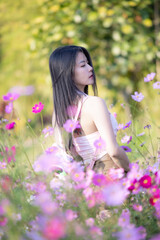 Wall Mural - Beautiful woman happy traveler walking in the flowers garden. Young woman smile and relaxing with happy  around outdoor garden. Woman's hand touching and enjoying beauty cosmos flowers.Travel concept.