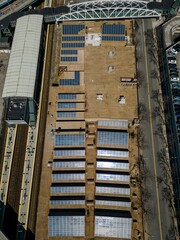 Sticker - Overhead aerial view of a large building surrounded by railway tracks in a city landscape