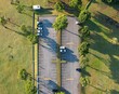 Aerial shot of a parking space surrounded by lush green fields