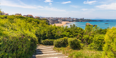 Rocky steps and view of Biarritz seen from the Pointe Saint-Martin on a sunny day in France