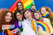 © Xavier Lorenzo - Diverse LGTBQ young people with rainbow flags celebrating gay pride parade festival. Cheerful gay and lesbian community friends demonstrating for LGTB equal rights. Transgenders and homosexual people.