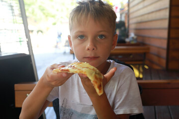 Child eating four cheese pizza