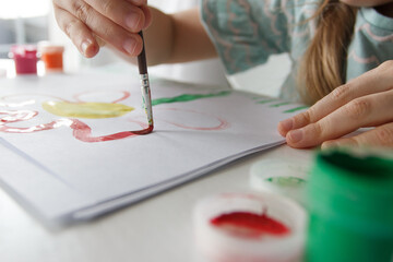 Little child draws with watercolor, concept of education in the kindergarten