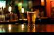 glass of beer in a darkly lit dive bar
