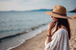 © Nedrofly - A woman wearing a hat standing on a beach