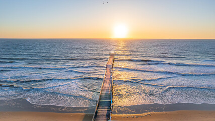 Wall Mural - Venerable wood fishing pier in Virginia Beach at sunrise.