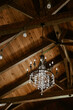 Black chandelier hanging from rustic wood rafter ceiling