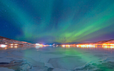 Wall Mural - cracks on the surface of the green ice next to white lone house (cabin) in winter - frozen lake - no