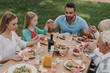 © gstockstudio - Top view of multi-generation family enjoying meal while having dinner outdoors together