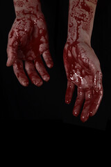 Fototapeta raised bloody creepy hands on a black background, the concept of murder, nightmares, halloween. vertical orientation