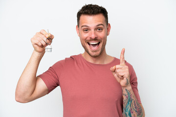 Wall Mural - Young caucasian man holding home keys isolated on white background pointing up a great idea