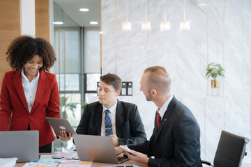 Mature business leader consultant talking to team of diverse colleagues listening to white CEO. Group project manager negotiating in the boardroom at a meeting.