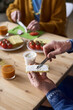 © Mediaphotos - Vertical image of senior couple having snack together at table, they eating sandwiches with vegetables