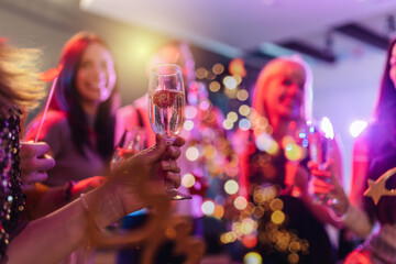 Group of friends partying in a nightclub and toasting drinks.