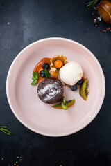 Wall Mural - Sweet chocolate cake with ice cream, fresh kiwi, blueberry, physalis and mint.