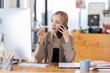 © David - Cheerful business Asian woman freelancer making telephone call share good news about project working in office workplace, business finance concept.