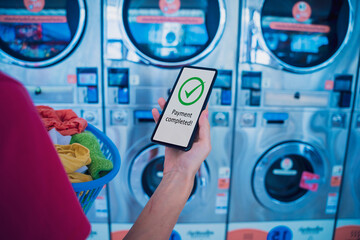 Young woman pays for laundry service using phone and banking application