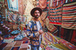 © Goffkein - Bearded guy traveling blogger at room with colorful carpets in Nevsehir, Goreme. Beautiful destination in Anatolia, Kapadokya
