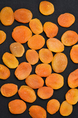 Wall Mural - Dried fruit background on a black background. Delicious dried apricots.