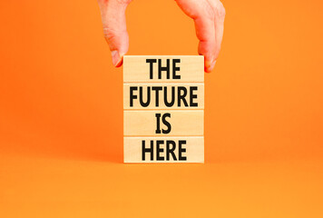 Wall Mural - The future is here symbol. Concept words The future is here on wooden block. Beautiful orange table orange background. Businessman hand. Motivational business the future is here concept. Copy space.
