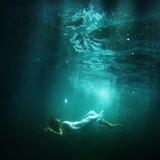 Fototapeta Zachód słońca - Woman floats underwater, dream fantasy