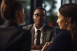 © wetzkaz - african american man in a suit communicates with two female people in an office or house, consulting or sharing a news. Generative AI