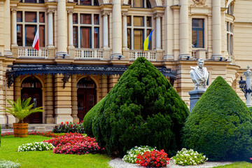 Wall Mural - Ukrainian and Polish flags on the facade of the Juliusz Slowacki Theatre. is a 19th-century Eclectic theater-opera house in the heart of Krak w, Poland, and a UNESCO World Heritage Site.